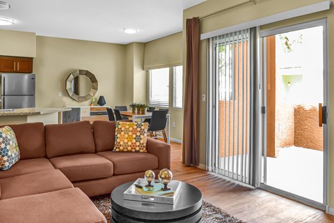 a living room with a brown couch and sliding glass doors